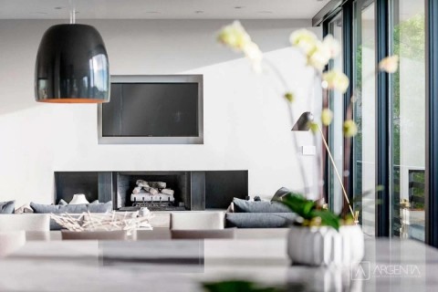 Luxury living room with ultra-modern furnishing and flat panel TV above a minimalist fireplace 