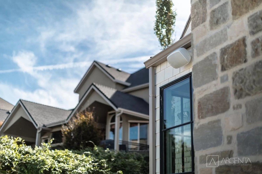 Exterior of luxury home with outdoor audio speakers mounted on the wall and throughout your yard.  