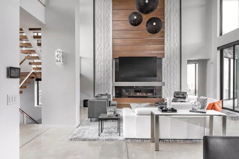 Vibrantly illuminated modern and minimalist living room colored in whites and blonde wood accents. 