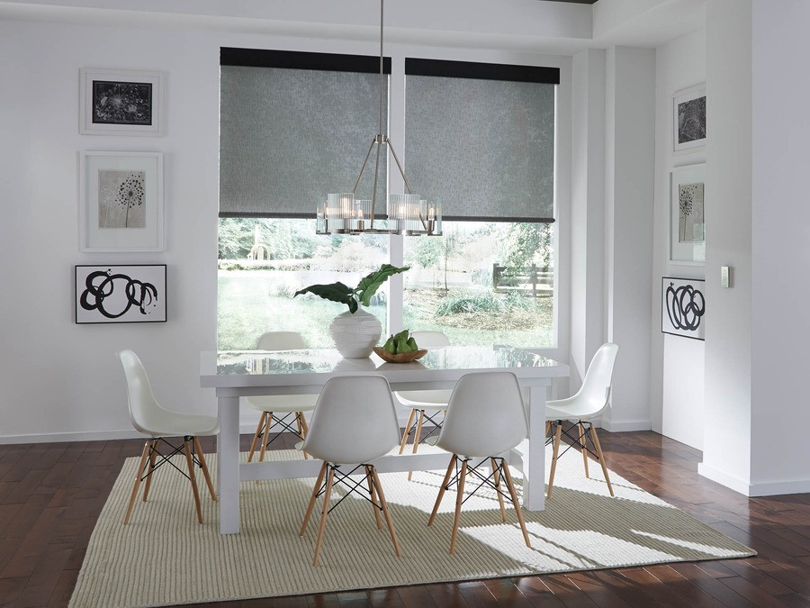 A sophisticated dining room with black motorized shades on the windows.