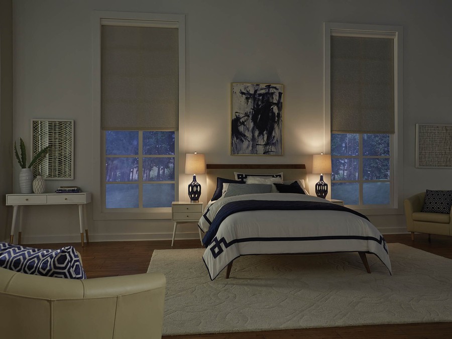 A bedroom with Lutron shades partially lowered over the windows.