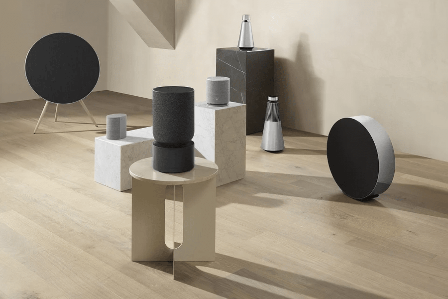  A variety of Bang & Olufsen speakers arranged on a wood floor.