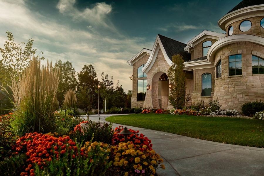 A home with unique architectural windows surrounded by beautiful gardens.