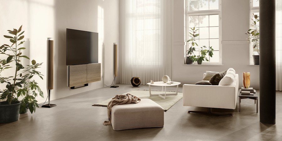 A stylish, modern living area with a sofa and Bang & Olufsen tower speakers and TV. 