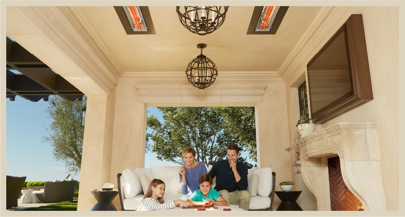 A family enjoying an outdoor patio area with two recessed Infratech heaters in the ceiling.