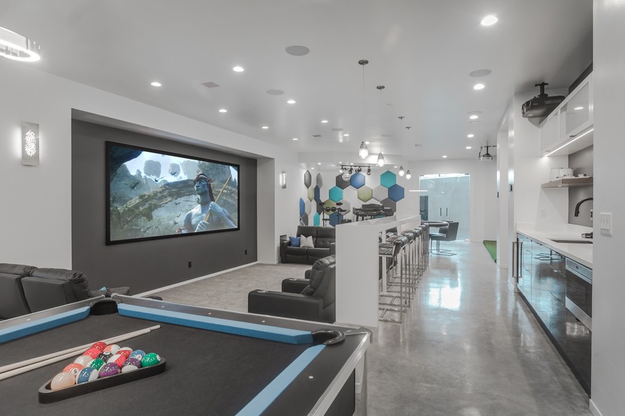 Modern home theater and gaming area with bartop seating behind the couch.
